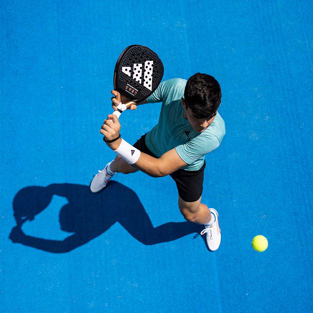 A man playing padel with an Adidas racquet