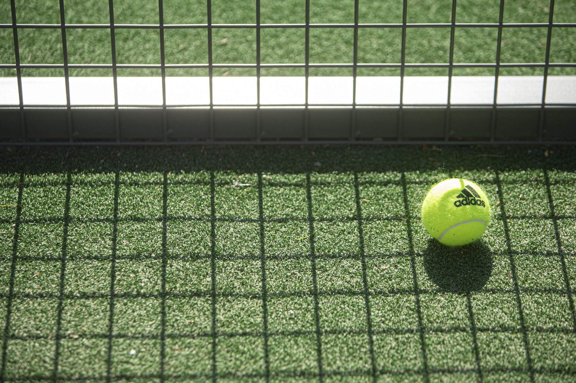 Adidas tennis ball on a padel court